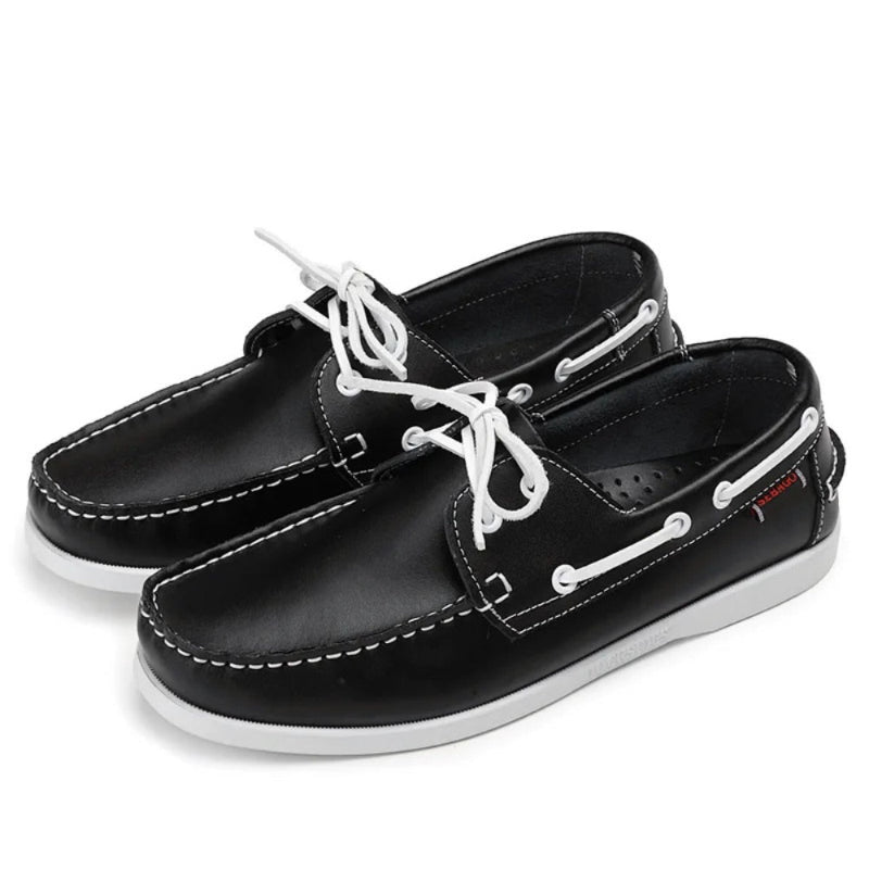 Pair of men’s leather boat shoes in black with white laces and white sole, premium casual moccasins with nautical stitching.