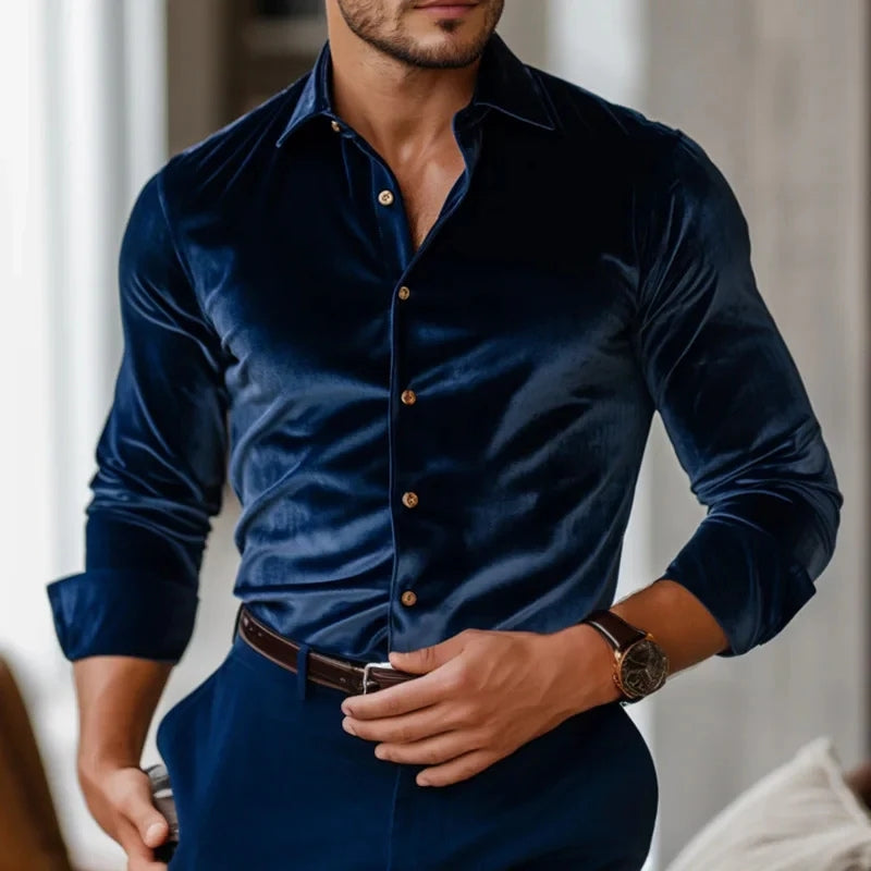 Man wearing a dark blue velvet shirt with gold buttons indoors.