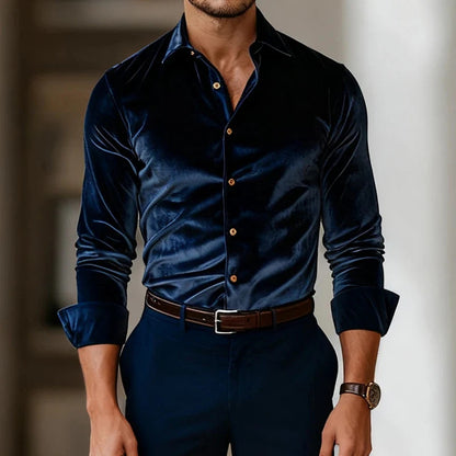Man wearing a dark blue velvet shirt with gold buttons and dark pants.