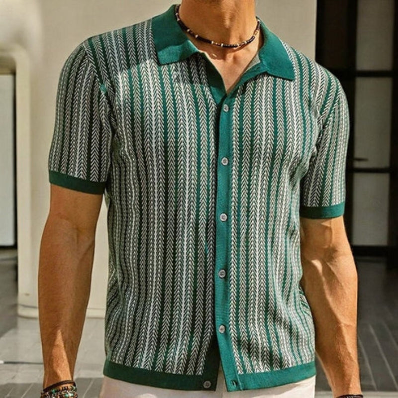 Person wearing a green and white patterned shirt with a blurred background
