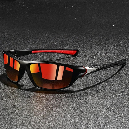 Sunglasses with black and red frame on a dark textured surface
