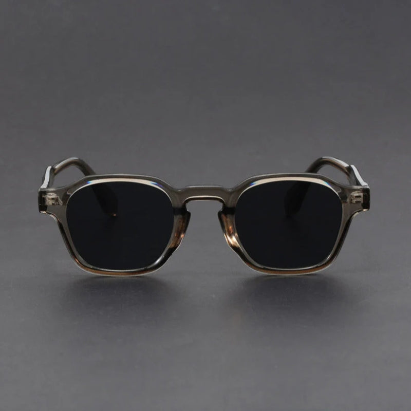Sunglasses with dark lenses and gold frame on a gray background