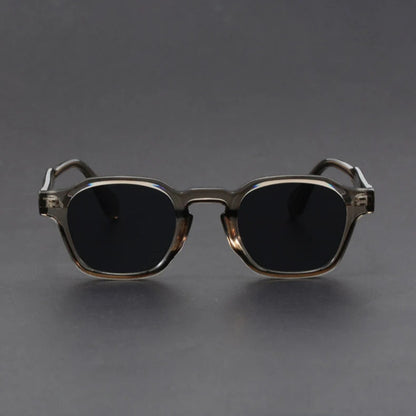 Sunglasses with dark lenses and gold frame on a gray background