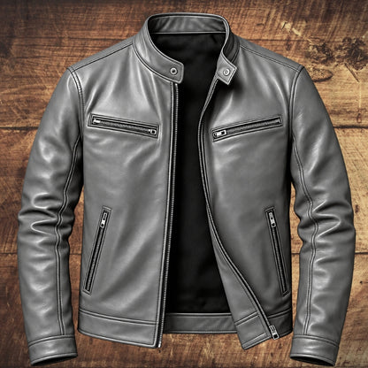 A gray faux-leather moto jacket with a stand collar, front zipper, and zippered chest and waist pockets, displayed on a rustic wooden background.