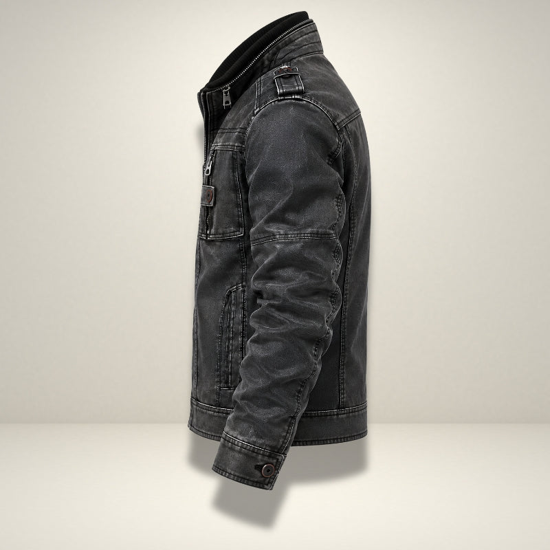 A dark gray washed denim jacket shown from a side profile view against a light gray studio background.