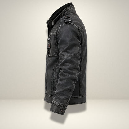 A dark gray washed denim jacket shown from a side profile view against a light gray studio background.