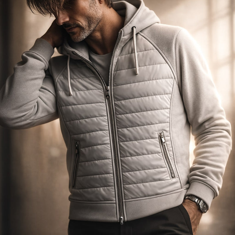 Man wearing a gray quilted jacket with a neutral background