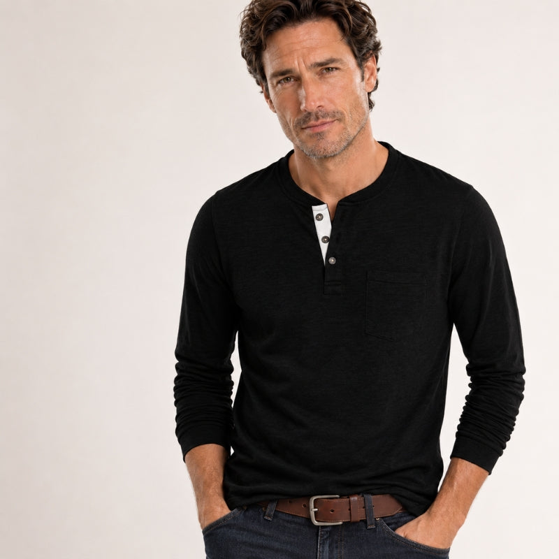 Man wearing a black long-sleeve henley shirt on a plain background
