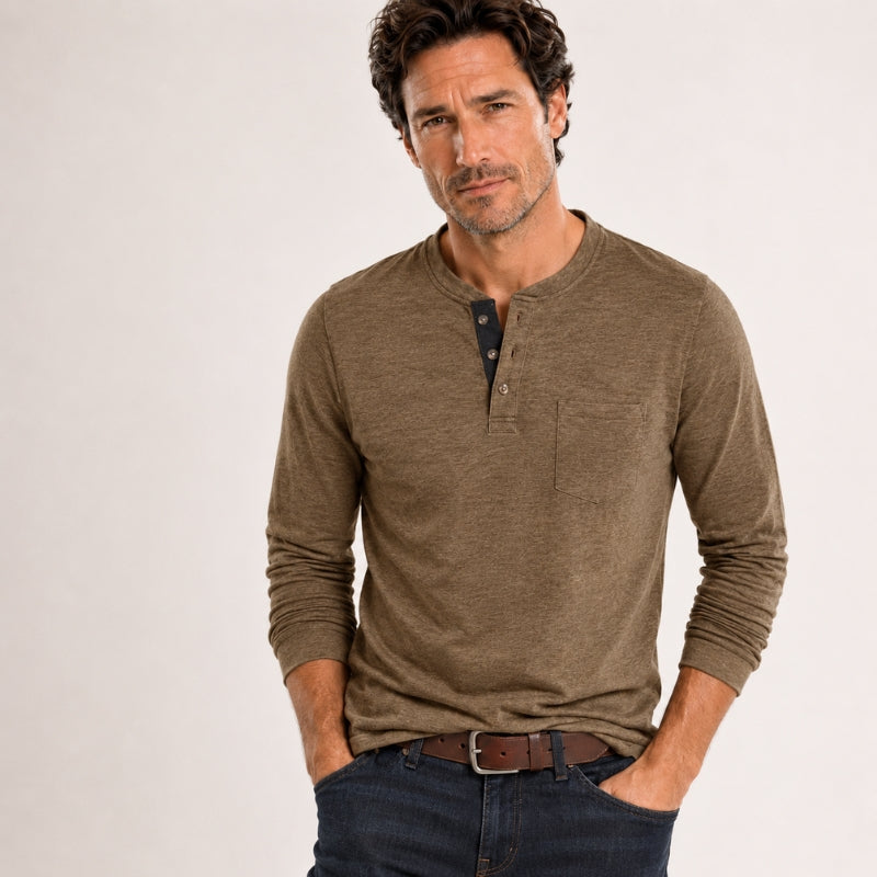 Man wearing a brown long-sleeve henley shirt and dark jeans on a light background