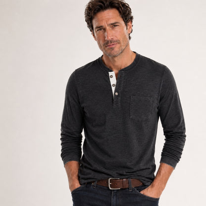 Man wearing a dark gray long-sleeve henley shirt on a light gray background