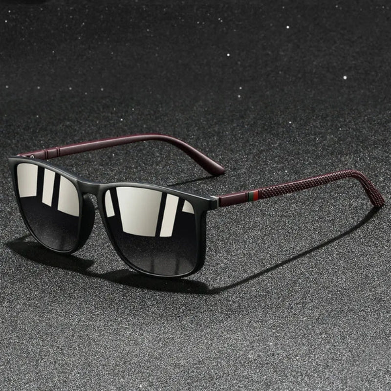 Sunglasses with dark lenses and red accents on a textured gray surface