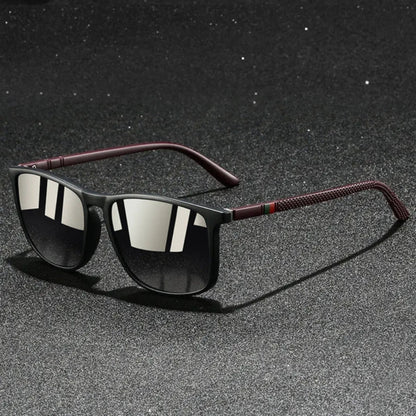 Sunglasses with dark lenses and red accents on a textured gray surface