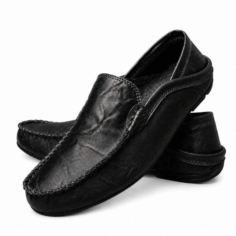 Pair of black leather loafers on a white background