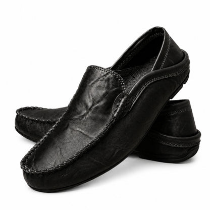 Pair of black leather loafers on a white background