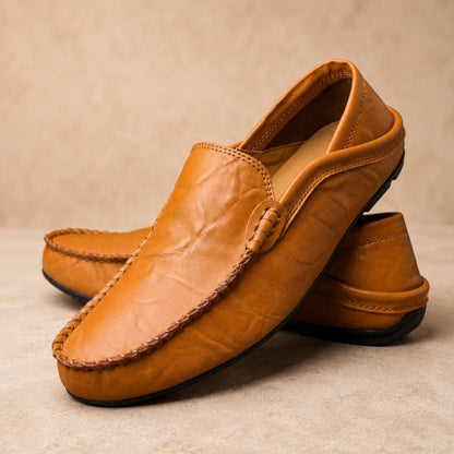 Pair of brown leather loafers on a beige background