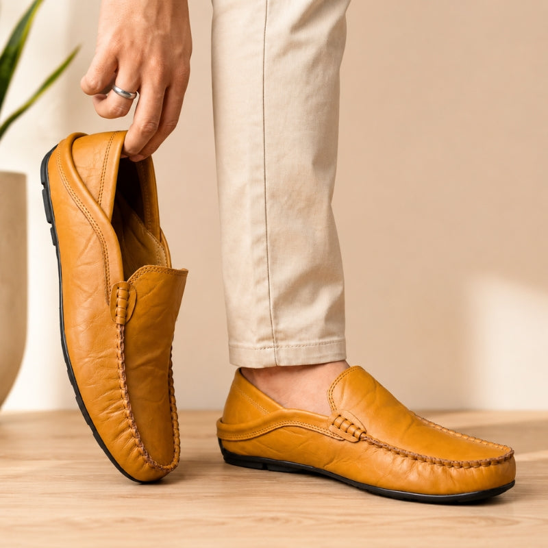 Person wearing yellow loafers with a neutral background
