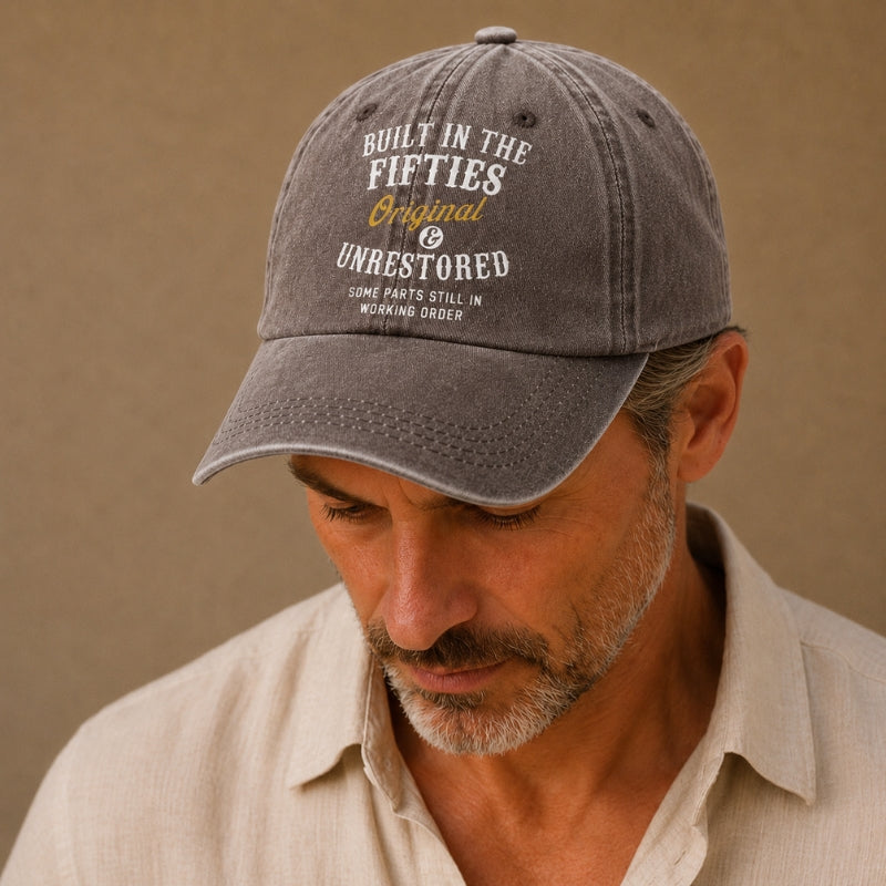 Man wearing a gray cap with text against a beige background