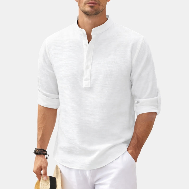 Man wearing a white long-sleeve shirt and white pants on a light gray background