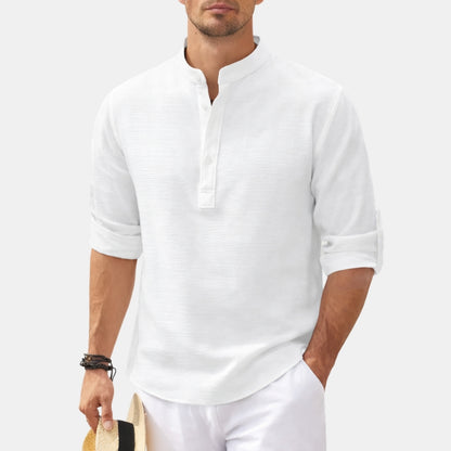 Man wearing a white long-sleeve shirt and white pants on a light gray background