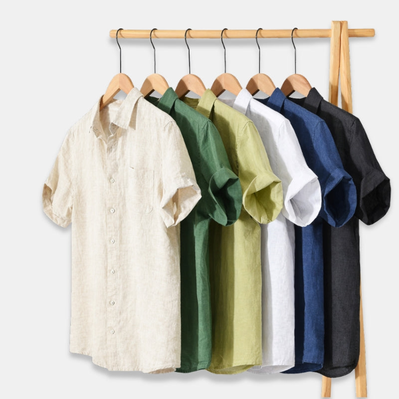 Set of five shirts in different colors hanging on a rack against a white background