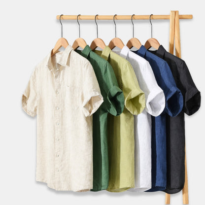 Set of five shirts in different colors hanging on a rack against a white background