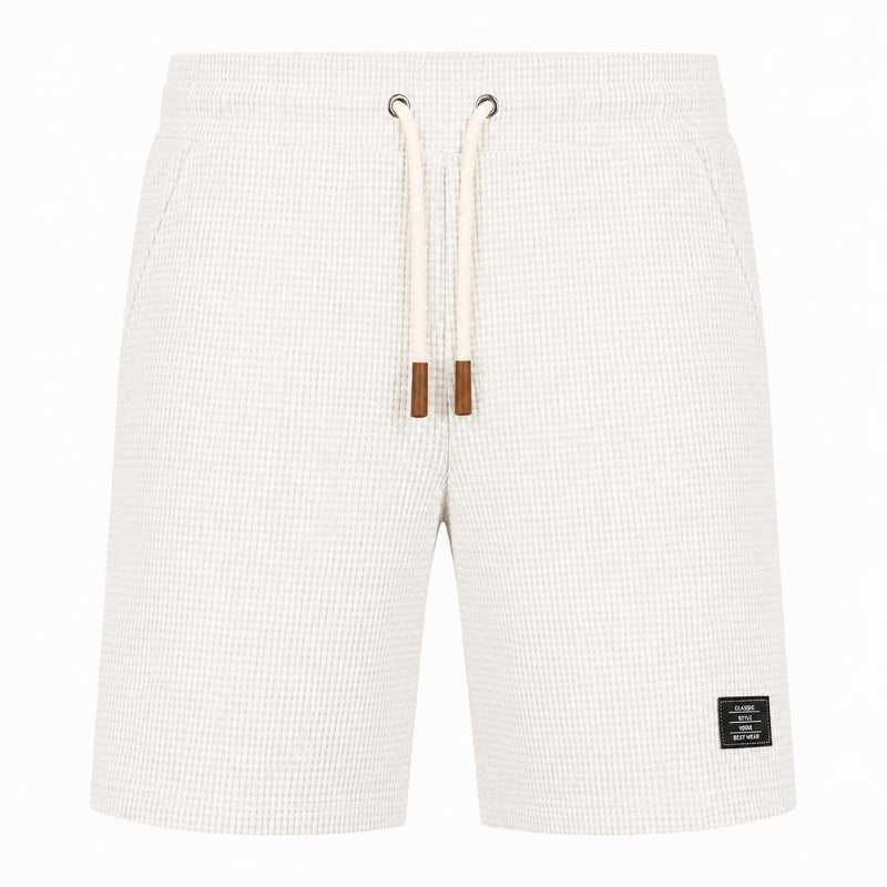 Off-white waffle-knit shorts with a cream drawstring and brown tips, shown against a plain white background.