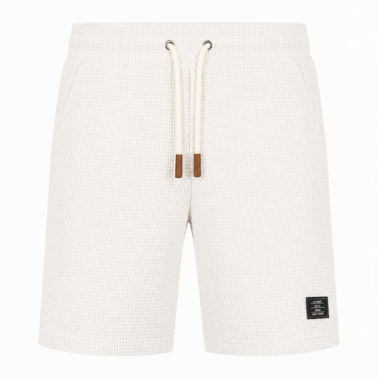 Off-white waffle-knit shorts with a cream drawstring and brown tips, shown against a plain white background.