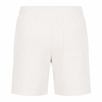 Off-white waffle-textured shorts with an elastic waistband and a single welt pocket on the left side, shown against a plain white background.