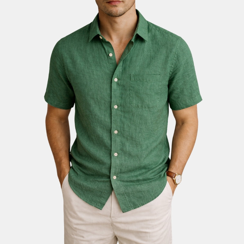 Man wearing a green short-sleeve shirt and beige pants on a white background