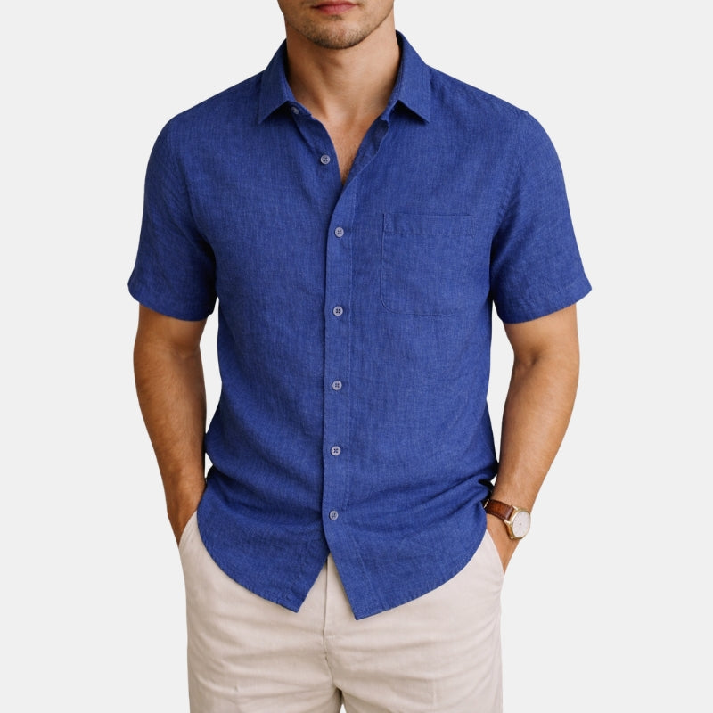 Man wearing a blue short-sleeve shirt and beige pants on a white background