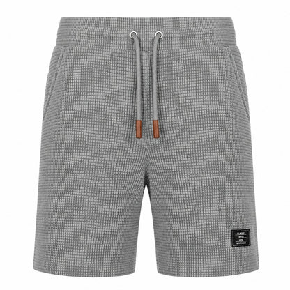 Gray textured knit shorts with a drawstring waist and a small black brand patch on the lower right leg, shown against a plain white background.