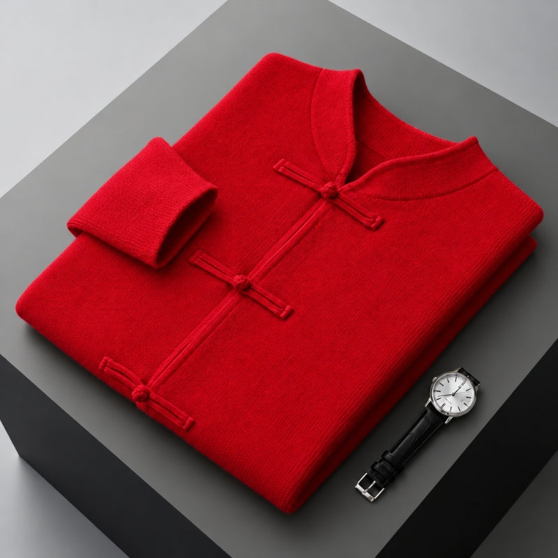 A folded bright red traditional Chinese-style knit top with a collar, buttoned front, and rolled cuff, displayed on a dark gray pedestal next to a wristwatch.