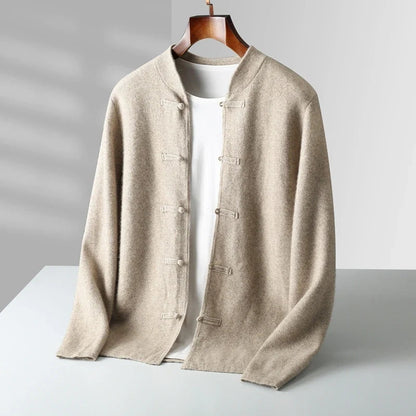 A beige open-front cardigan with a round neckline and traditional Chinese-style toggle closures, layered over a white t-shirt and displayed on a wooden hanger against a light gray background.