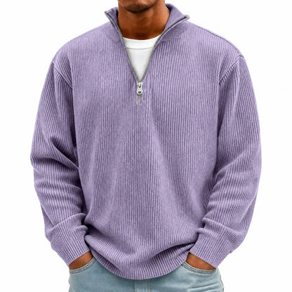 A man wearing a light purple ribbed quarter-zip pullover sweater over a white t-shirt and light blue jeans, shown from the neck down against a plain white background.