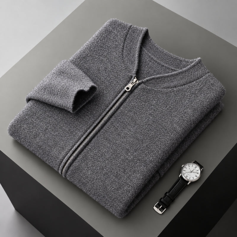 A folded gray zip-up sweater is displayed on a dark gray pedestal, with a black leather strap watch placed beside it.