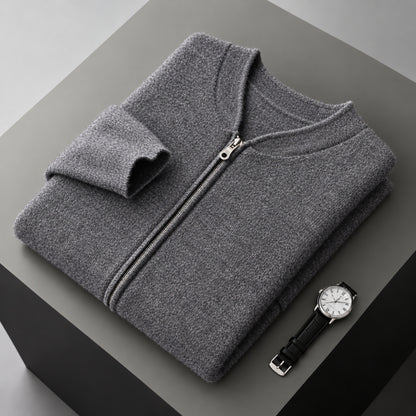 A folded gray zip-up sweater is displayed on a dark gray pedestal, with a black leather strap watch placed beside it.