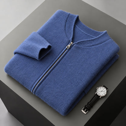 A folded blue zip-up sweater or lightweight jacket with a ribbed collar and cuffs, displayed on a dark gray pedestal next to a black-strapped wristwatch.