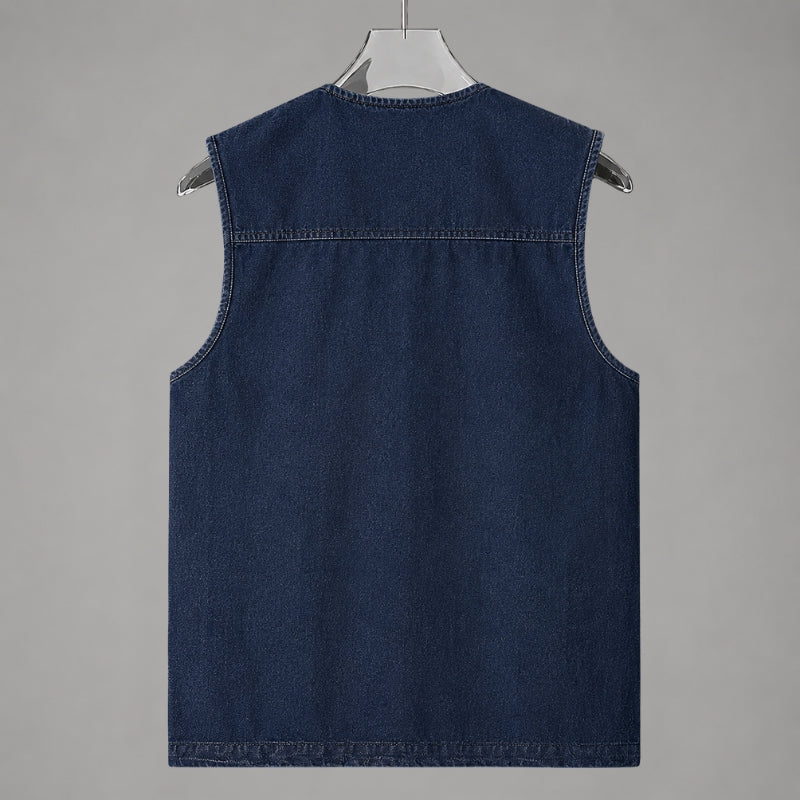 A dark blue denim sleeveless vest hanging on a white hanger against a solid gray background.