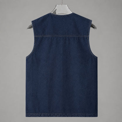 A dark blue denim sleeveless vest hanging on a white hanger against a solid gray background.