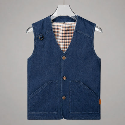 A dark blue denim vest with a V-neck, three button closures, and two large front patch pockets, hanging on a clear plastic hanger against a solid gray background.