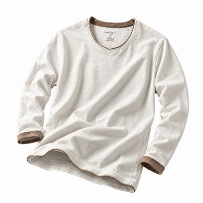 A long-sleeve V-neck t-shirt in off-white cotton-linen fabric, featuring contrasting brown ribbed trim at the collar, cuffs, and hem, displayed on a clean white background.
