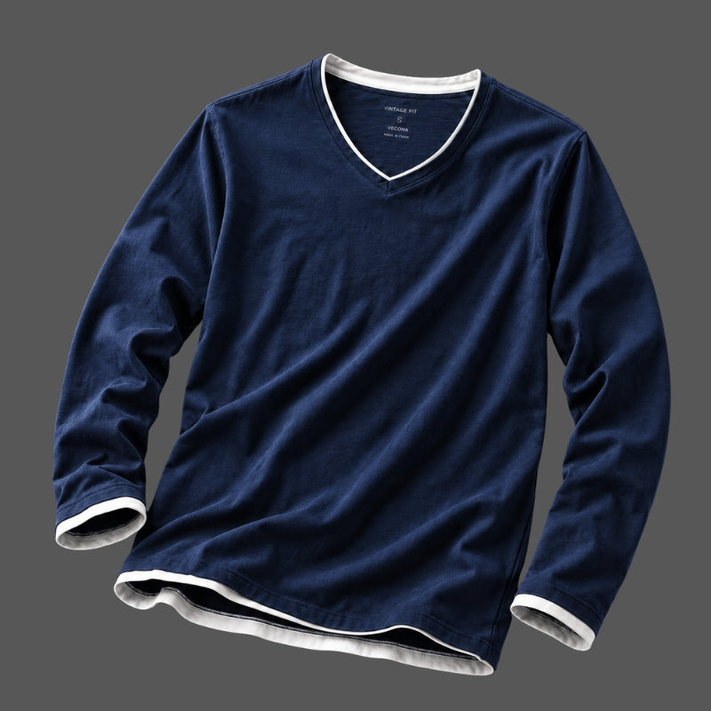 A navy blue long-sleeve V-neck t-shirt with white ribbed trim on the collar, cuffs, and hem, displayed against a solid dark gray background.