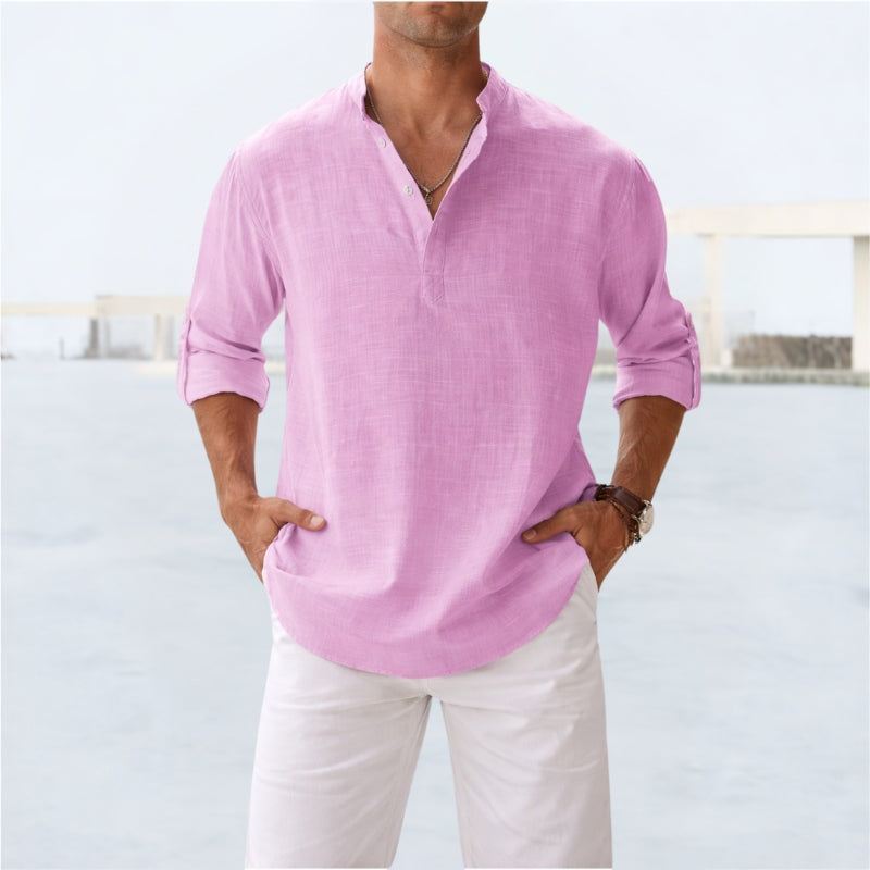 Person wearing a light pink long-sleeve shirt and white pants against a light background