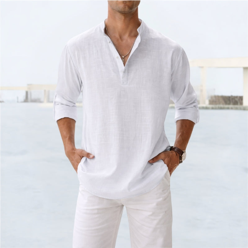 Man wearing a white long-sleeve shirt and pants with a blurred background