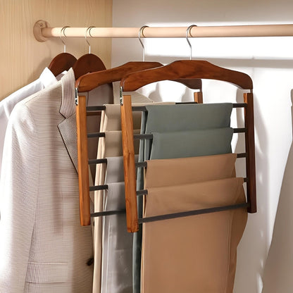 Wooden hanger with multiple hooks holding clothes on a rack.