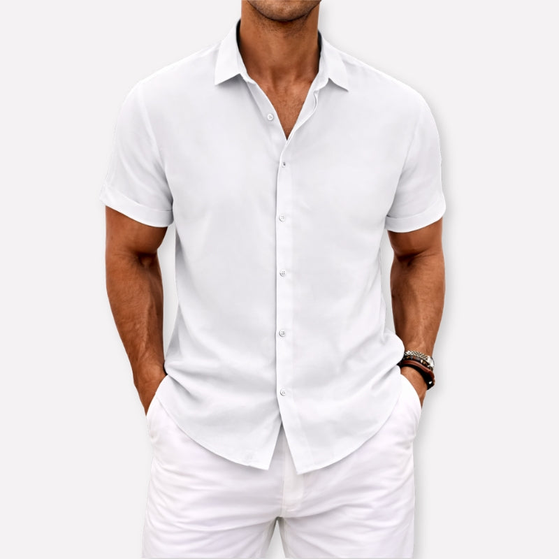 Man wearing a white short-sleeve shirt and pants against a white background