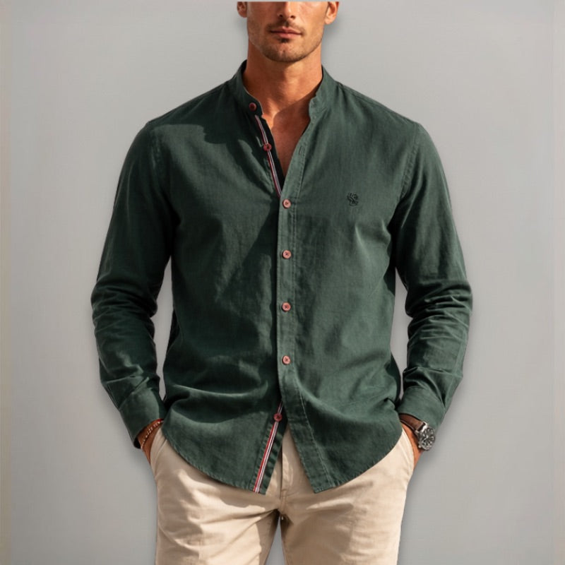 Man wearing a green button-up shirt with a plain background
