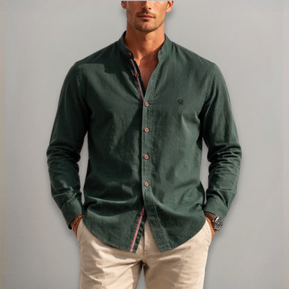 Man wearing a green button-up shirt with a plain background
