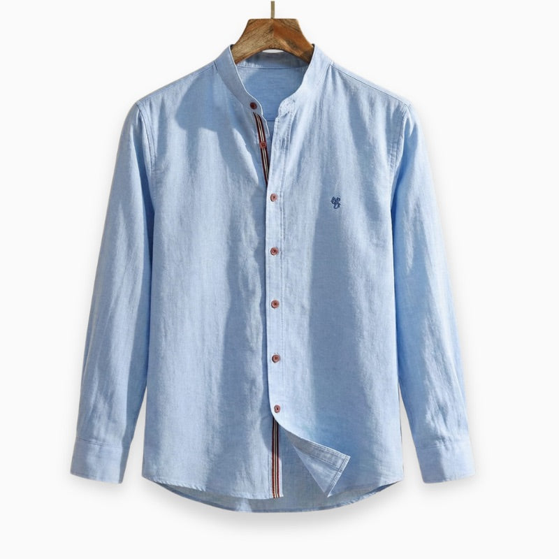 Light blue button-up shirt on a wooden hanger against a white background