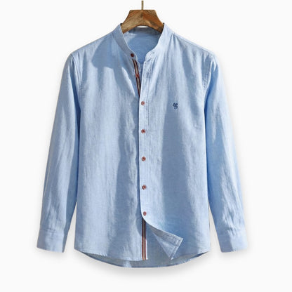 Light blue button-up shirt on a wooden hanger against a white background